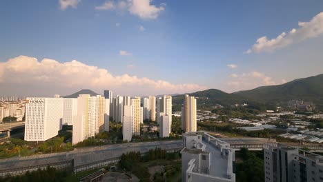 Seoul-Seocho-Hills-and-Nature-Hills-Apartments-and-Hoban-Company-Office---cloudscape-clouds-movement-over-Guryongsan-and-Cheonggyesan-mountains-and-high-rooftops-buildings-complexes-daytime