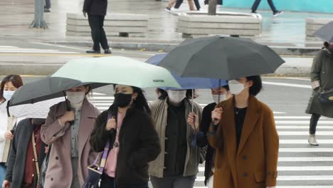 Peatones-Coreanos-Con-Sombrillas-Cruzando-La-Calle-En-Un-Día-Lluvioso-En-Dongdaemoon,-Seúl,-Corea-Del-Sur