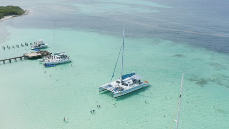 AERIAL---Catamaran-boat-on-clear-waters,-Cayo-Icacos,-Puerto-Rico,-forward-descending