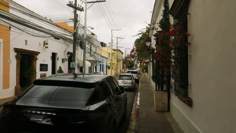 Cars-Parked-On-The-Roadside-In-Front-Of-Houses-In-Santo-Domingo-City,-Dominican-Republic