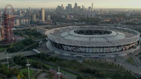 Luftaufnahme-Des-Londoner-Stadions,-Heimat-Des-Fußballclubs-West-Ham-United-Im-Vereinigten-Königreich,-Mit-Blick-Auf-Die-Skyline-Von-London-Im-Hintergrund