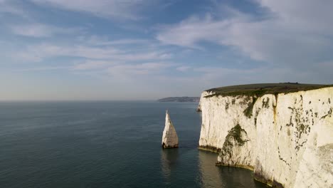 Drone-flying-along-cliff-and-toward-stunning-stack,-Old-Harry-Rocks-on-Purbeck-island,-Dorset-in-England
