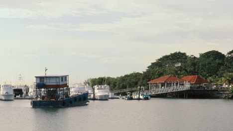 El-Capitán-De-Una-Barcaza-Navegando-Cuidadosamente-Por-Un-Puerto-Deportivo-Lleno-De-Yates-De-Lujo-De-Alta-Gama,-Canal-De-Panamá