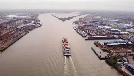 High-Aerial-View-Of-Bolero-Cargo-Ship-Navigating-Forward-Along-River-Noord