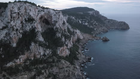 Imponentes-Acantilados-Rocosos-Y-Cuevas-En-La-Isla-De-Ibiza,-Tiro-De-Pedestal-De-Drones