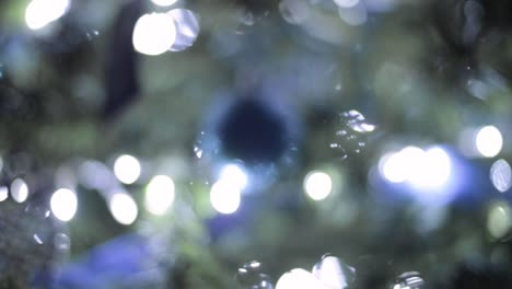 Hermosos-Adornos-De-Burbujas-De-Navidad-Azul-En-Un-Pino-De-árbol-Con-Luces-De-Bokeh-Centelleantes