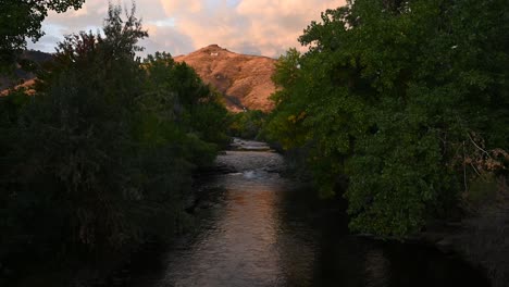 Agua-Que-Fluye-Por-Clear-Creek-En-Golden-Colorado-Durante-El-Día-Con-La-Escuela-De-Minas-De-Colorado-M-En-El-Fondo