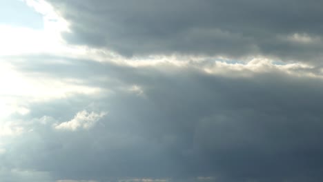 Wolken-Ziehen-Am-Himmel,-Sonnenstrahlen-Blicken-Durch-Weiße,-Dicke-Wolken