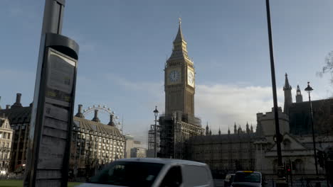 Una-Vista-Espectacular-Del-Big-Ben-Mientras-El-Sol-De-La-Mañana-Ilumina-La-Icónica-Torre-Del-Reloj-En-Un-Hermoso-Día,-Los-Viajeros-Pasan-La-Mañana-Pasando-La-Parada-De-Autobús-En-La-Plaza-Del-Parlamento,-Londres,-Reino-Unido