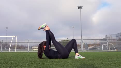 Sporty-Girl-Laying-on-Back-Stretching-Legs-After-Workout,-Slow-Motion