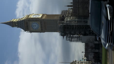 A-vertical-video-of-the-beautiful-Big-Ben-clocktower-from-Parliament-Square,-the-scaffolding-is-being-removed-from-the-iconic-landmark-after-the-completion-of-the-restoration-project,-London,-England