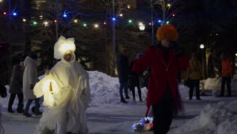 Blick-Auf-Menschen,-Die-Beim-Porvoo-Light-Festival-Uusimaa-In-Finnland-Um-Wunderschöne-Beleuchtete-Kleider-Tanzen,-Wobei-Der-Boden-Nachts-Mit-Weißem-Schnee-Bedeckt-Ist
