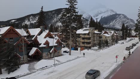 Wide-view-Banff-avenue-covered-in-snow,-Mountains-in-distance,-Ski-town
