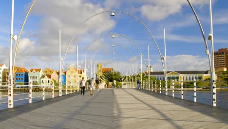 People-crossing-the-floating-Queen-Emma-Bridge-in-Punda-Willemstad,-on-the-Caribbean-island-of-Curacao