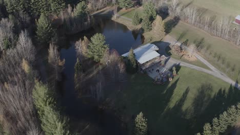 Drohnen-Luftaufnahme-Eines-Wunderschönen-Grundstücks,-Das-In-Einen-Veranstaltungsort-Für-Hochzeiten-Umgewandelt-Wurde,-Mit-Einem-Großen-Teich-Und-Einer-Reihe-Alter-Gebäude-In-Der-Region-Ottawa