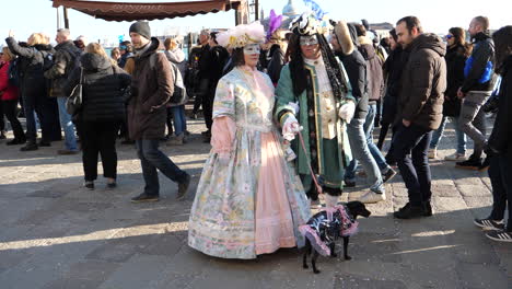 Ein-Paar-Im-Karneval-Von-Venedig-Trägt-Traditionelle-Kostüme-Und-Eine-Maske,-Die-Einen-Verkleideten-Hund-Hält