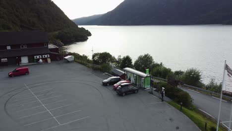 Three-electric-cars-lined-up-at-charging-station-in-Norway-summer-evening---Fortum-roadside-charger-for-electric-cars-in-Akrafjorden---Norway-Aerial