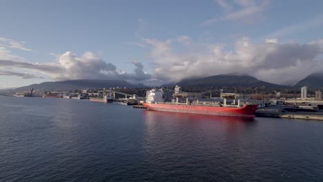 Cargo-ship-in-Vancouver-commercial-port-with-mountains-in-background,-Canada