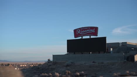 Sign-welcoming-travelers-to-Rosamond,-California-in-the-Mojave-Desert-as-seen-from-a-car-driving-into-the-city-limits