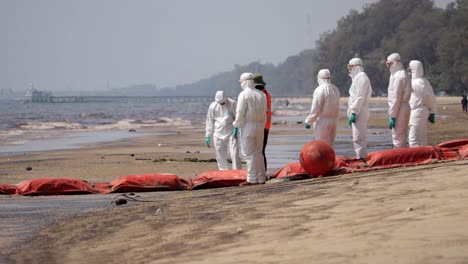 Arbeiter-In-Weißen-PSA-Anzügen-Führen-Aufräumarbeiten-Aufgrund-Einer-Ölpest-Am-Strand-Von-Mae-Ram-Phueng-In-Rayong,-Thailand-Durch