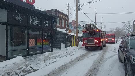 Firetrucks-in-front-of-a-storefront-in-Kensington-Market,-Toronto,-during-a-snowfall