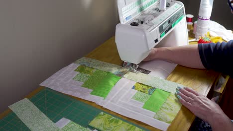 Sewing-quilt-block-together-on-a-sewing-machine---slow-motion-log-cabin-pattern
