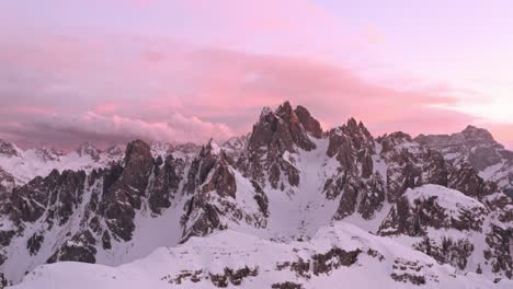 Dolly-forward-drone-shot-towards-Candini-Group-Italian-dolomites-in-winter-beautiful-pink-sunset