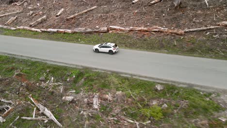 Un-Subaru-Crosstrek-Blanco-Solitario-Conduciendo-A-Través-De-Un-área-Forestal-Clara,-Vía-Aérea,-Editorial-Ilustrativa