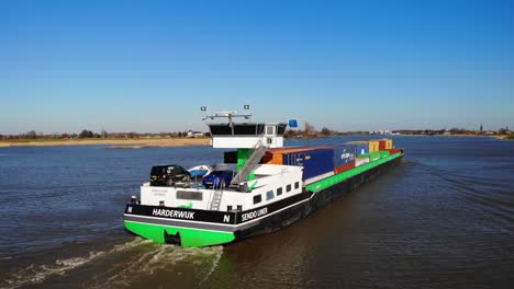 Aerial-From-Stern-Of-Sendo-Liner-Inland-Freighter-With-Circle-Dolly-Left-Along-Der-Lek-In-Groot-Ammers