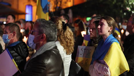 Ukrainian-People-In-Tears-Attend-Peace-Vigil-With-Candlelight-And-Stop-War-Placard-During-The-Russo-Ukrainian-War-At-Night-In-Leiria,-Portugal