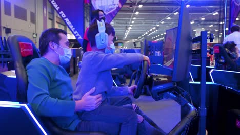 Son-and-a-father-play-themed-racing-videogames-during-the-International-Motor-Expo-showcasing-thermic-and-electric-cars-and-motorcycles-in-Hong-Kong
