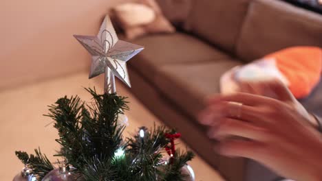 Die-Spitze-An-Den-Geschmückten-Weihnachtsbaum-Legen-–-Das-Letzte-Stück-Dekoration
