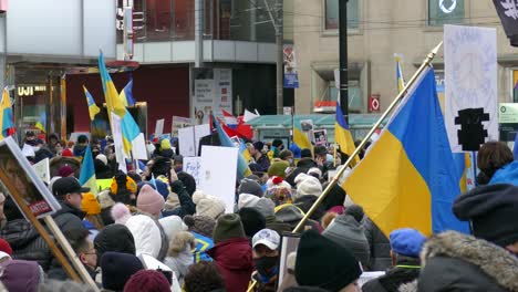 Peaceful-demonstration-of-people-against-the-Russian-invasion-of-Ukraine,-with-Ukrainian-flags-gathered-at-Nathan-Phillips-Square