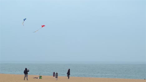 Familia-Con-Niños-Volando-Cometas-En-La-Playa-De-Barcelona