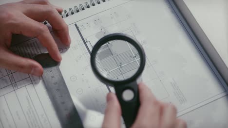 Construction-site-foreman-reviewing-the-blueprints-with-a-magnifying-glass,-construction-inspector-concept