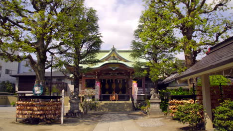Asakusa,-Tokio,-Japón-Alrededor-De-Abril-De-2020:-Hombre-Adorando-En-Un-Auténtico-Templo-Japonés,-Hermosa-Arquitectura-Con-Hermoso-Techo,-En-Un-Tranquilo-Y-Tranquilo-Jardín-De-Estilo-Zen-En-Un-Soleado-Día-De-Primavera
