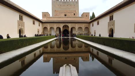 Tilt-down-wide-open-view-inside-Alhambra,-Granada-courtyard-on-cloudy-day