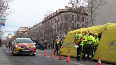 Ein-Medizinischer-Notfallwagen-Fährt-Vorbei,-Während-Teams-In-Madrid,-Spanien,-Eine-Evakuierungsübung-Durchführen