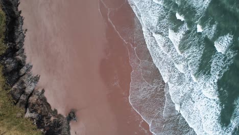 Luftaufnahme:-Dolly-Von-Oben-Nach-Unten-Am-Orangefarbenen-Sandstrand,-Blaue-Poolbucht,-4K-Drohne