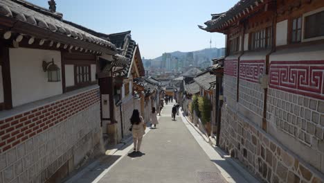 People-take-photos-and-walk-along-the-street-of-Bukchon-Hanok-Village-in-Seoul,-South-Korea