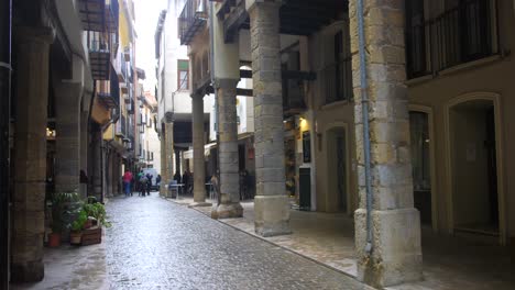 Panning-across-medieval-European-style-architecture-with-pillars-and-beautiful-alley-in-Morella-old-town-center,-Spain