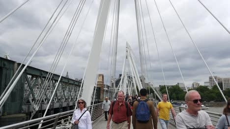 People-walking-along-Golden-Jubilee-Bridge-Editorial-use-only
