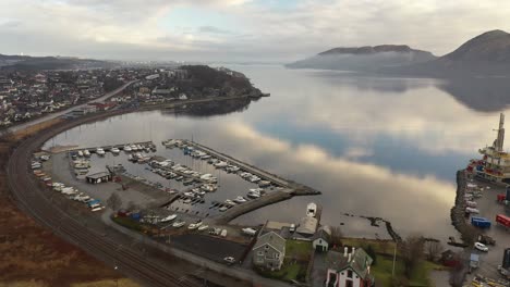 Sandnes-Marina-Und-Somaneset-In-Der-Lura-Bucht---Norwegen-Luftaufnahme-Mit-Wunderschönen-Himmelsreflexionen-Im-Fjord---Eisenbahn-Sørlandsbanen,-Die-In-Der-Nähe-Des-Yachthafens-Vorbeiführt