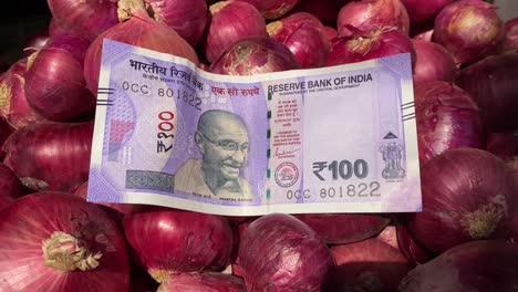 Billete-De-100-Rupias-Guardado-En-Un-Fondo-De-Cebolla-Para-Mostrar-La-Inflación-En-El-Aumento-De-Precios-De-Los-Alimentos-En-India