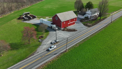 Red-barn-with-PA-Dutch-Amish-hex-sign-and-white-farmhouse