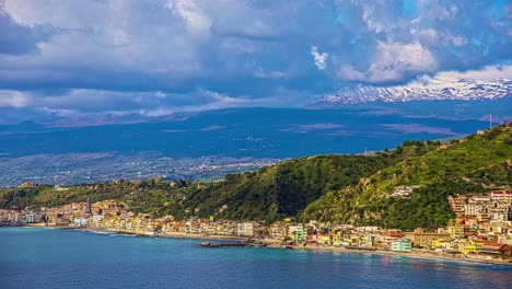 Static-view-of-the-seaside-town-of-Mesina,-Sicily,-Italy-with-the-view-of-etna-volcano-in-the-background-on-a-cloudy-day-in-timelapse