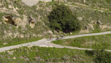 Two-people-cycle-up-a-country-road-in-the-small-Spanish-village-of-Chulilla