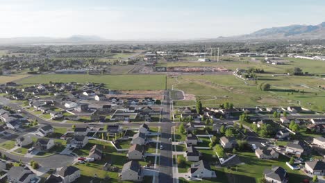 Comunidad-De-Hogares-En-El-Norte-De-Utah-Con-Cordillera-En-El-Fondo-Vista-Aérea-De-Drones-4k