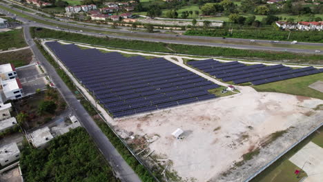 Aerial-View-Of-Rows-Of-Photovoltaic-Solar-Panels-Beside-CEPM-Energy-Plant-In-Punta-Cana