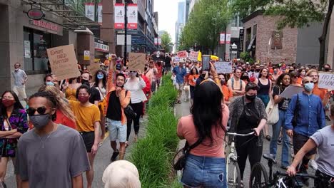 Cancelar-El-Día-De-Canadá,-Miles-De-Manifestantes-En-Camisa-Naranja-Marchan-En-El-Centro-De-Vancouver-Con-Pancartas-En-Canadá